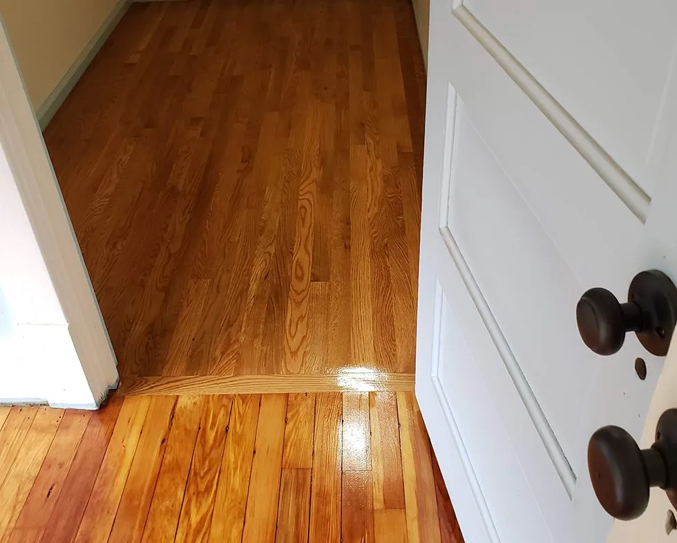 Refinished living room hardwood floor with a gloss finish